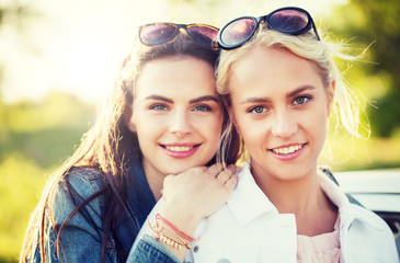 Wall Mural - summer vacation, holidays, friendship and people concept - happy smiling young women or teenage girls outdoors