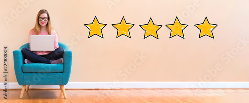 Fotomural Five star rating with young woman using her laptop in a chair