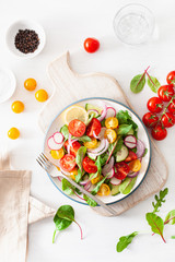 Canvas Print - healthy colorful vegan tomato salad with cucumber, radish, onion