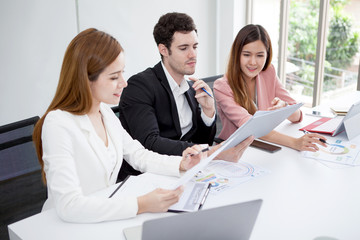 Group of happy business people men and woman working together with paper document file in meeting room.teamwork of two girl asian and caucasian man discussing in office