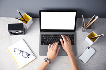 Wall Mural - Female blogger using laptop at table, top view. Blank screen for mockup