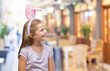 © Krakenimages.com - Young beautiful girl wearing easter bunny ears over isolated background looking away to side with smile on face, natural expression. Laughing confident.