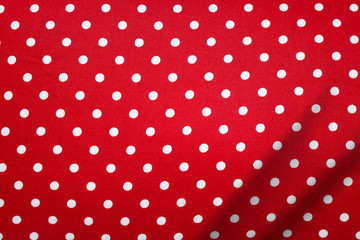 Wall Mural - Red fabric in polka dots pattern background. Modern textile texture. Detail of clothing. Christmas concept.