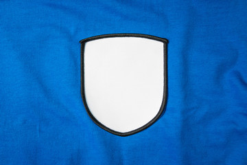 blank arm patch on blue sport shirt. white team logo and emblem for your montage or edit.