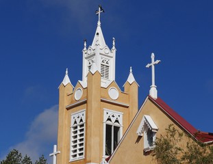 Wall Mural - Full closeup of the tower of the San Felipe de Neri Parish, a historic catholic church on the Old Town Plaza of Albuquerque, New Mexico  