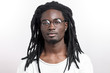 Handsome muscular black man with dreadlocks wearing glasses looking camera on white backgound