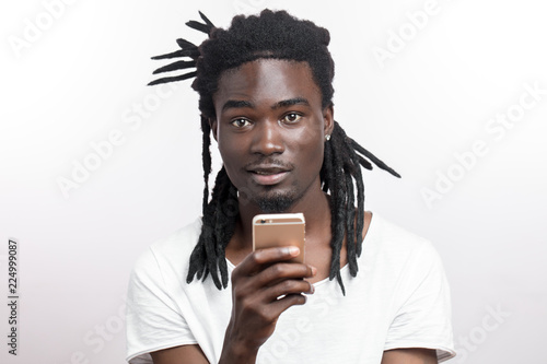 Dark Skinned Man With Dreadlocks In White T Shirt Looking At
