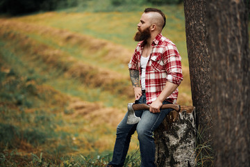 Wall Mural - Lumberjack worker sitting in forest resting after hard work