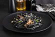 Pasta with wheat germ and black squid ink. Mushroom sauce. Olive oil and spices. Copy space.
