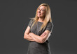 © luismolinero - Middle age blonde woman on grey background keeping the arms crossed while smiling