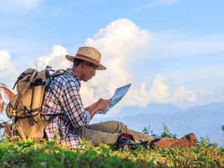 Wall Mural - hiker with backpack checks map to find directions in wilderness area