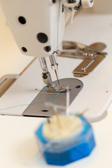 The mechanism of the sewing machine and pincushion with needles.