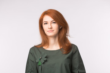 Portrait of beautiful young woman with red hair over white background