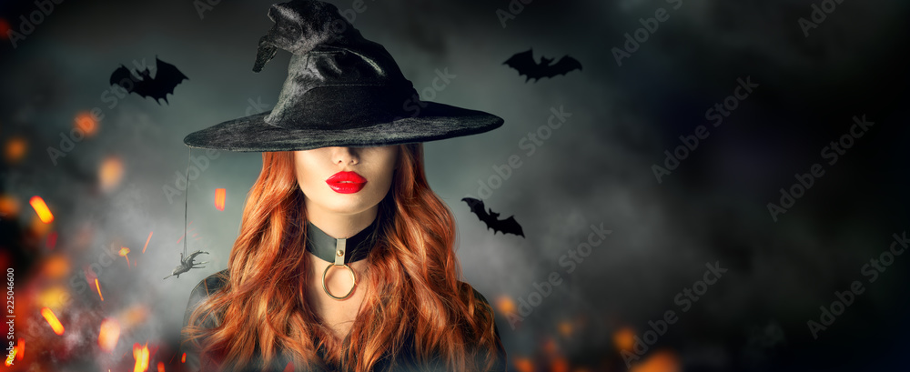 Halloween. Sexy witch portrait. Beautiful young woman in witches hat with long curly red hair - obrazy, fototapety, plakaty 
