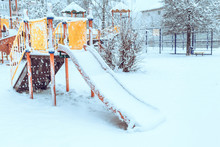 An Empty Children's Playground In The Courtyard Of High-rise Buildings During A Snowfall.  Slide For Rolling.