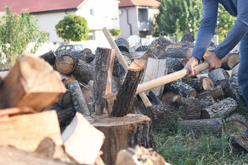 Lumberjack chopping wood for winter, Young man chopping woods with old ax