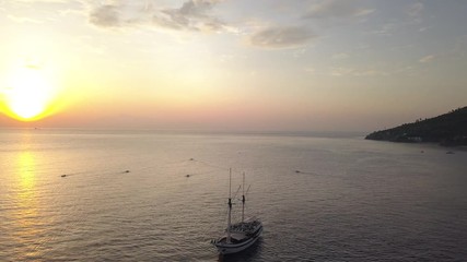 Wall Mural - morning flight over calm lagoon in indian ocean with sail boat on water surface
