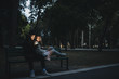 © Strelciuc - Couple chilling on bench with smartphone