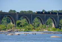 Train Traveling Across Arched Bridge Over River In Richmond, VA
