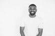 © sofiko14 - Positive human emotions, facial expressions, feelings, attitude and reaction. African American man dressed in white t-shirt and jeans posing in studio on white background . black and white portrait