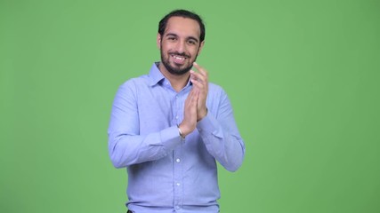 Wall Mural - Young happy bearded Indian businessman clapping hands