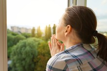 Mature Woman Looking Out The Window, Close-up View From The Back