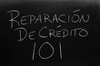 The words Reparación De Crédito 101 on a blackboard in chalk.  Translation: Credit Repair 101