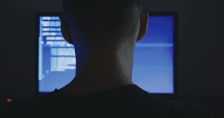 IT Programmer man typing in program code. Developer at work overtime. Hacker hacking late at night.