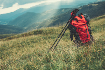 professional backpack for tourists standing in the grass with a beautiful scenary in the background