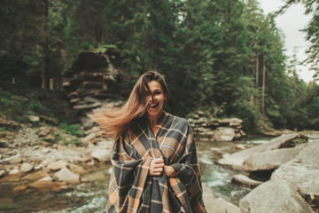 Wall Mural - Cheerful attractive young woman expressing happiness while resting in the forest