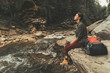 © Yakobchuk Olena - Delighted beautiful young woman sitting on the bank of mountain river while enjoying amazing scenary
