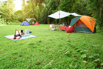 nature landscape camping tent with tarp and child family under tree on green grass meadow in jungle 