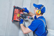 © Kadmy - electrician at work. cutting concrete wall for cabling by diamond slitting machine