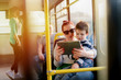 © dusanpetkovic1 - Young caring mother sitting with son in a bus. Boy is sitting in her lap and looking at tablet.