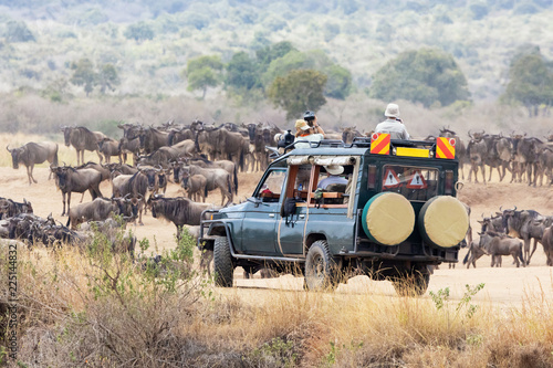Fotomural Photographers shooting wildebeest in the Masai Mara