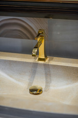 Wall Mural - Golden faucet and marble wash basin. close up