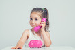 © Myst - beautiful cute little girl talking on toy telephone with curious expression