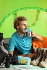 Poster - Young man in sleeping bag with mug inside of tent