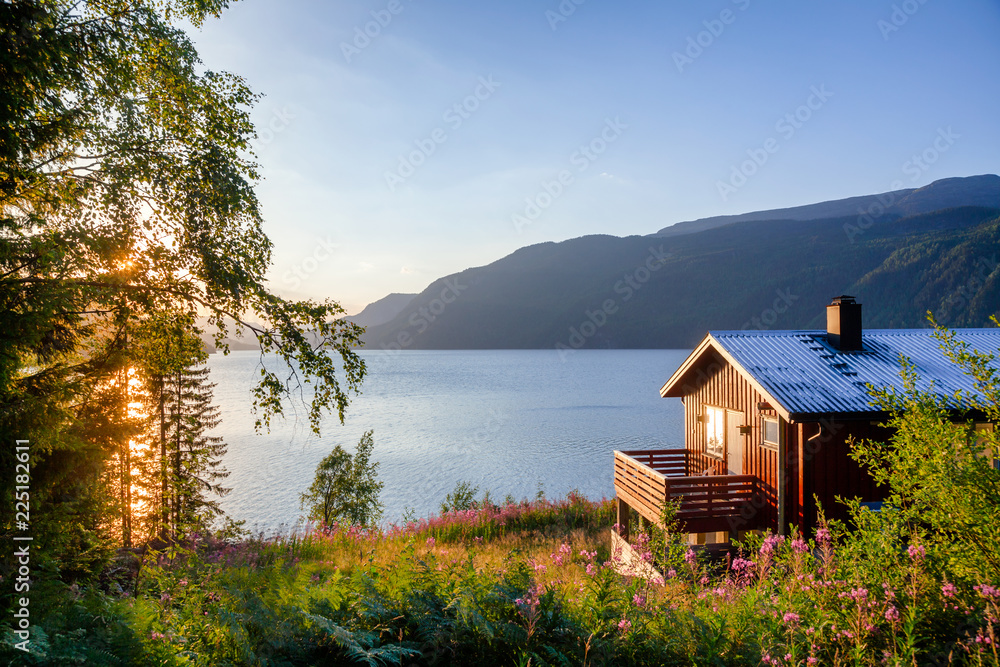 Wooden summerhouse with terrace overlooking scenic lake at sunset in Norway Scandinavia - obrazy, fototapety, plakaty 