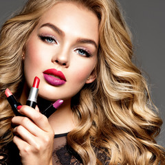 BBeautiful woman holds  lipsticks. Makeup.  Beauty concept