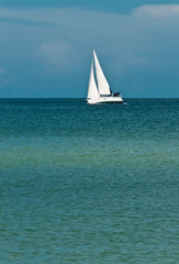  Front view, long distance of a sailing vessel underway from  a strong wind, on an autumn, windy day on the tropical waters of the gulf of mexico