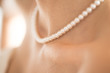 Junge Frau trägt Perlenhalskette