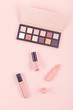 Makeup cosmetic products over pastel pink background, flat lay, top view
