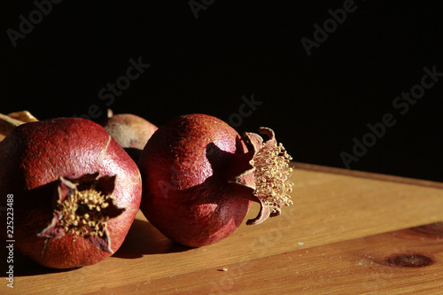 Fotografía Still life with Couple of Dry Pomegranates on the wooden table,