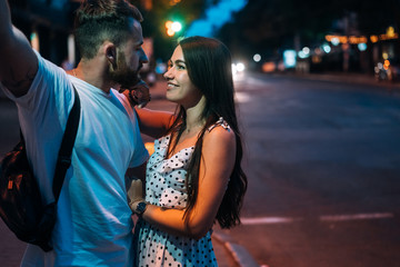 Young couple in the streets of the evening city