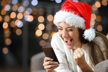 Excited Woman Reading Text On A Phone On Christmas