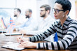 © Seventyfour - Country representatives meeting at conference: serious attractive lady with black hair sitting at table and making notes, flag of united kingdom on table