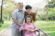 Happy asian family. Grandson take care grandma in the park.