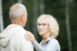 © pressmaster - Mature blonde woman touching her husband shoulder while comforting him outdoors
