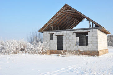 Wall Mural - House construction in winter. Unfinished home roofing metal tiles construction. Roofing Construction in Winter.